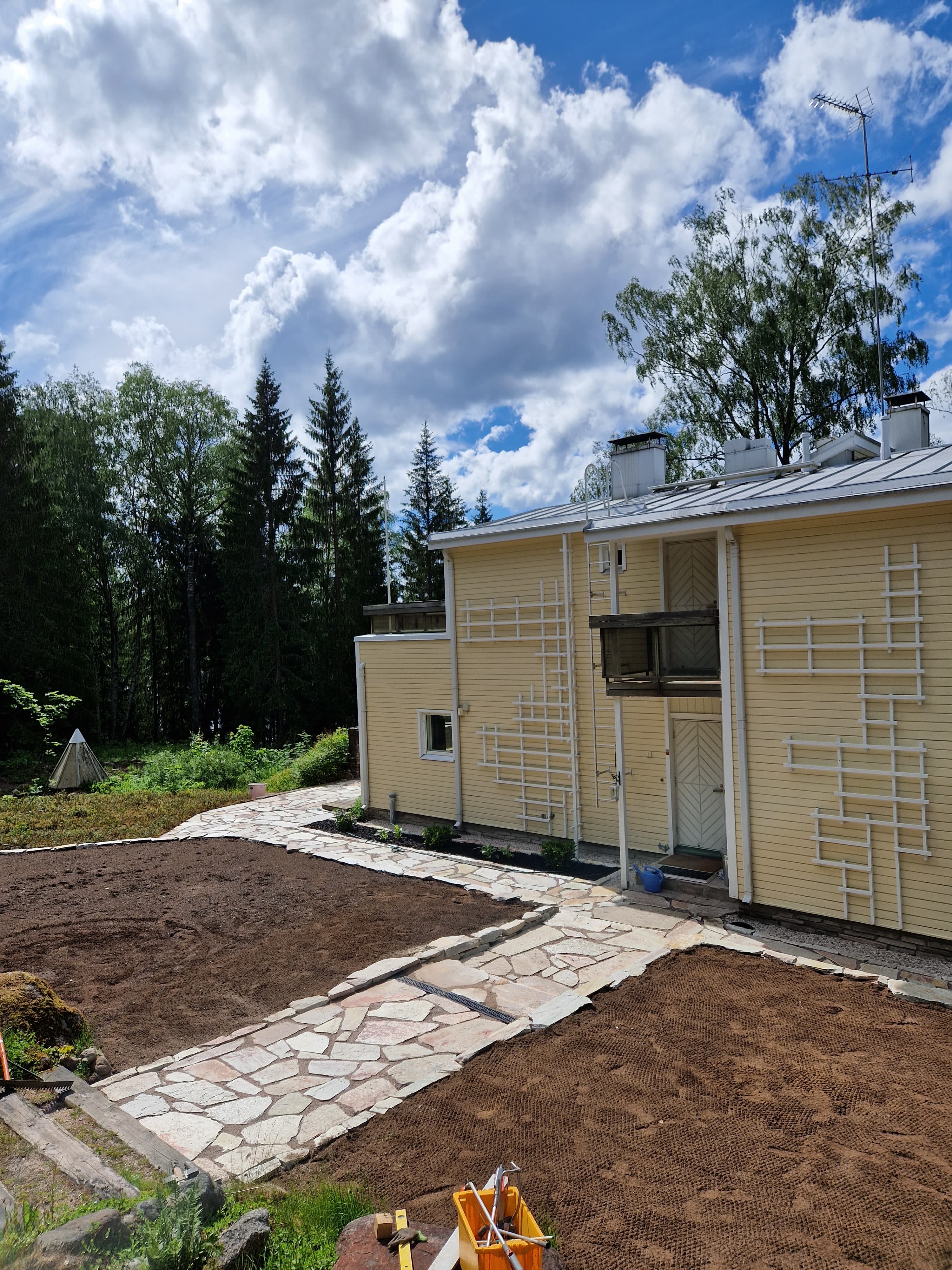 Luonnonkivetty kulkuväylä ja valmisteltu kasvualusta rakennuksen vierellä